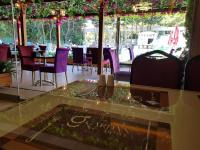 Una mesa de cristal en un restaurante con sillas moradas. en Gardan Hotel, en Beylikduzu