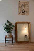 a mirror on a table next to a lamp and a plant at La Brocante - Meilleurhote-Brioude in Brioude
