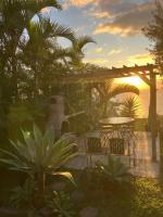 - une table et des chaises sur une terrasse avec vue sur le coucher du soleil dans l&#39;établissement Chambre d&#39;hôtes Austral 180, à La Possession