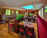 a restaurant with a table and chairs and a bar at Haus Hubertus in Winterspelt