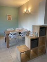 a dining room with a wooden table and chairs at Appartement calme, climatisé 3min à pied de la mer in Palavas-les-Flots