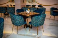 a dining room with a wooden table and blue chairs at Redwaves Hotel in Jeddah