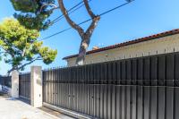 a fence in front of a house with trees at Sea terace apartment between Nice and Monaco - 3 in Villefranche-sur-Mer