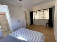 a bedroom with a bed and a large window at L’Arabesque, villa de charme avec piscine in Arradon