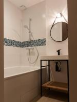 a bathroom with a tub and a sink and a mirror at L’Arabesque, villa de charme avec piscine in Arradon