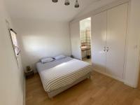 a white bedroom with a bed and a closet at L’Arabesque, villa de charme avec piscine in Arradon