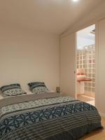 a bedroom with a large bed and a glass door at L’Arabesque, villa de charme avec piscine in Arradon