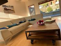 a living room with a couch and a table with a bowl of fruit at L’Arabesque, villa de charme avec piscine in Arradon