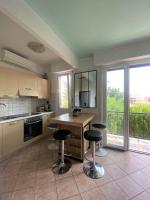 a kitchen with two bar stools and a table with a view at Chris&#39;Home2 in Roquebrune-Cap-Martin
