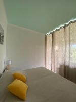 a bedroom with a bed with yellow pillows and a window at Chris&#39;Home2 in Roquebrune-Cap-Martin