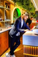 a man in a suit standing at a bar at Amicitia - Hôtel &amp; Restaurant in LʼIsle-Adam