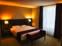 a hotel room with a large bed and a window at Amicitia - Hôtel &amp; Restaurant in LʼIsle-Adam