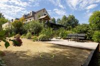 a house with a bench in front of a garden at Amicitia - Hôtel &amp; Restaurant in LʼIsle-Adam