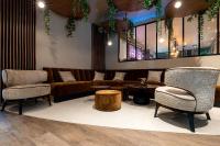 a lobby with a couch and chairs and tables at Amicitia - Hôtel &amp; Restaurant in LʼIsle-Adam