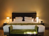 a large bed in a hotel room with two lamps at Amicitia - Hôtel &amp; Restaurant in LʼIsle-Adam