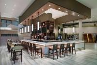 a large kitchen with a bar with chairs and tables at DoubleTree by Hilton Hotel Newark Airport in Newark