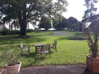 a picnic table and two benches in a park at L&#39;Atelier à l&#39;orée des bois in Saint-Pierre-sur-Dives