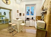a kitchen with a counter and stools in a room at Caporizon-Sarlat l&#39;élégance-T2 Plein centre cité médiévale in Sarlat-la-Canéda