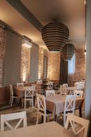 a restaurant with tables and chairs and a large chandelier at Hotel Piano Kvareli in Kvareli