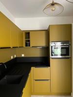 a kitchen with yellow cabinets and a stove top oven at L&#39;Oasis urbaine : détente totale in La Rochelle