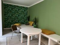 a white table and chairs in a room with a green wall at L&#39;Oasis urbaine : détente totale in La Rochelle