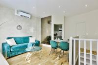 - un salon avec un canapé bleu et une table dans l&#39;établissement Cosy appartement - Eiffel Tower, à Paris
