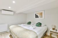 - une chambre blanche avec un lit et des serviettes dans l&#39;établissement Cosy appartement - Eiffel Tower, à Paris