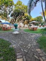 a park with tables and chairs and a fountain at Pousada São Francisco in Cumuruxatiba