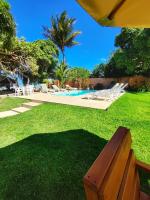 a bench sitting in the grass next to a pool at Pousada São Francisco in Cumuruxatiba
