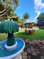 a statue of a pineapple in a fountain in a park at Pousada São Francisco in Cumuruxatiba