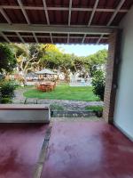 a patio with a table and chairs in a yard at Pousada São Francisco in Cumuruxatiba