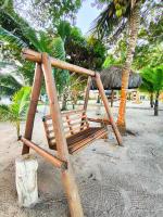 a wooden swing on a beach with a hut at Pousada São Francisco in Cumuruxatiba