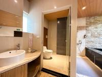 a bathroom with a sink and a toilet and a tub at Yage Hotspring House in Jiaoxi