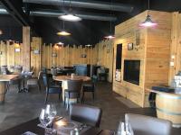 Chalet cosy proche mer في Vandré: مطعم به طاولات وكراسي وجدران خشبية