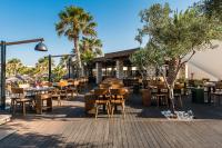 a restaurant with tables and chairs on a patio at Stella Palace Aqua Park Resort in Hersonissos