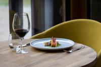 un plato de comida y una copa de vino en una mesa en Hotel Boè Sport and Nature, en Arabba