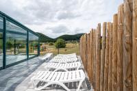 a row of white benches on a deck next to a wooden fence at Camping Les Vosges du Nord in Oberbronn
