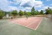 a group of people playing tennis on a tennis court at Camping Les Vosges du Nord in Oberbronn