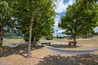 two hammocks in a park with trees and a playground at Camping Les Vosges du Nord in Oberbronn