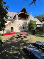 a picnic table and chairs in front of a building at Les gîtes de La Pellerie - 2 piscines &amp; spa Jacuzzi - Touraine - 3 gîtes - familial, calme, campagne in Saint-Branchs