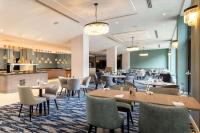 Un restaurante con mesas y sillas y un bar. en Hilton London Gatwick Airport, en Horley