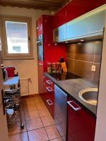 a kitchen with red cabinets and a sink at Appartement cosy, esprit chalet avec jolie vue in Saint-Gervais-les-Bains