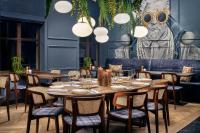 Un comedor con mesas y sillas y una estatua. en Court Hotel Utrecht City Centre, en Utrecht