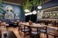 Un restaurante con mesas y sillas y un mural de monos. en Court Hotel Utrecht City Centre, en Utrecht