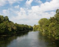a river with trees on both sides of it at Beautiful riverside boathouse in Bourg-Charente
