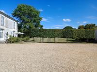 a hedge in a yard next to a building at Beautiful riverside boathouse in Bourg-Charente