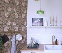 a kitchen with a sink and a wall with floral wallpaper at Le Perchoir Gîte de charme dans château in Brix
