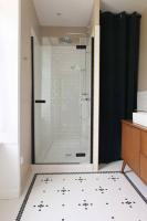 a shower with a glass door in a bathroom at Le Perchoir Gîte de charme dans château in Brix