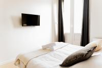 - une chambre avec un lit et une télévision murale dans l&#39;établissement Le moderne - Beau T2 - Belle vue sur les quais - Centre - Tram, au Mans