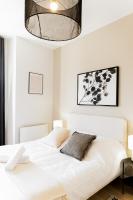 - une chambre avec un lit blanc et un lustre dans l&#39;établissement Le moderne - Beau T2 - Belle vue sur les quais - Centre - Tram, au Mans